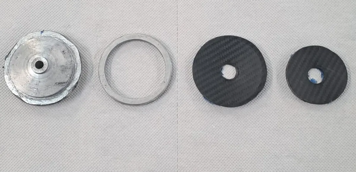 Self-produced CFRP Belleville discs next to the CNC-machined tronco-conical molds